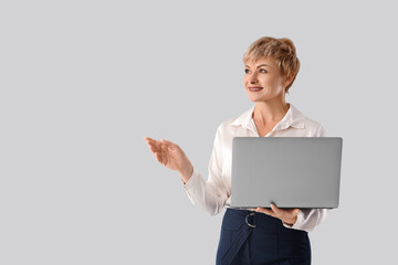 Naklejka premium Mature businesswoman with laptop on white background