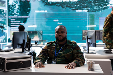 POV of soldier transmitting real time battlefield data on videocall, working in army base of...