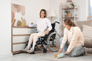 Young woman in wheelchair and her friend at home