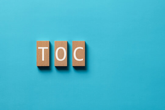 There is wood block with the word TOC. It is an abbreviation for Theory Of Constraints as eye-catching image.
