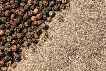 Texture of black pepper powder and peppercorns as background