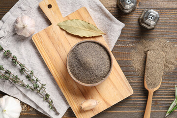 Bowl with black pepper powder and different spices on wooden background