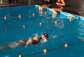 Competitive swimming practice takes place in indoor pool setting
