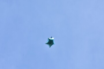 balloon floating through blue sky background