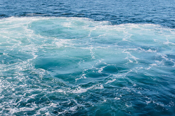 teal, blue, white waves in wake
