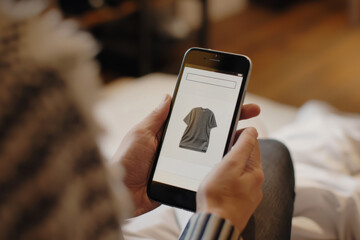 A person browsing an online shopping app for a t-shirt on smartphone