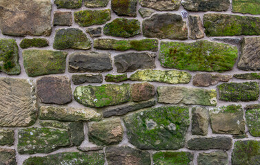 A beautiful renovated stone wall covered in lichen