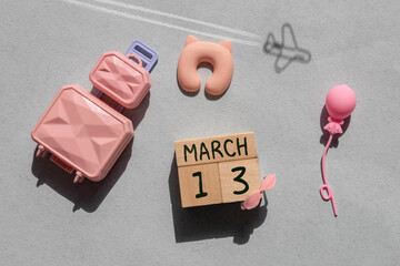 Wooden block calendar with date March 13 on colored pastel backround.