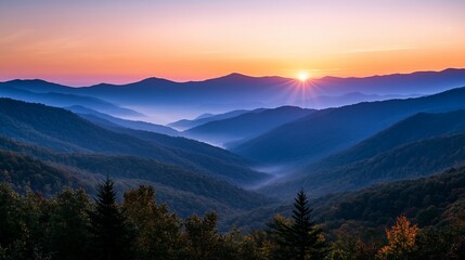 Obraz premium Majestic sunrise over layered mountain ranges, showcasing vibrant colors and misty valleys.