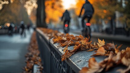 Autumn leaves on a bridge with cyclists in the background.