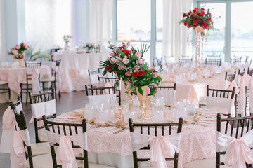 Elegant event space with floral centerpieces and pink decor at a waterfront venue