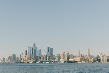 Fototapeta premium City skyline viewed from the water during a clear day with boats visible on the horizon