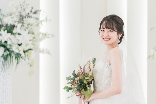 結婚式場でブーケを持つ花嫁・新婦の女性（横顔）

