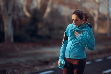Tired Jogger Feeling a Pain in her Chest Taking a Break. Running woman feeling sick after intense...