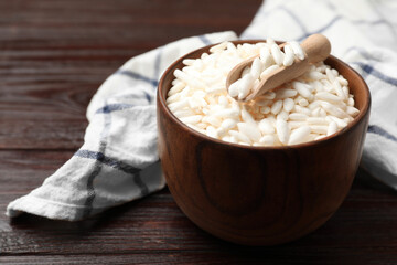 Puffed rice in bowl and scoop on wooden table, closeup