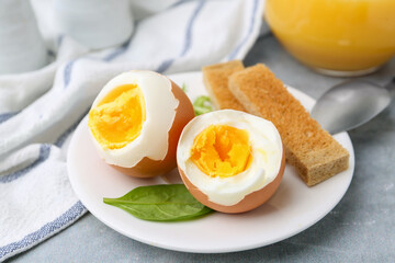 Soft boiled eggs with bread on grey table, closeup