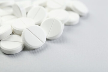 Many antibiotic pills on grey background, closeup. Space for text