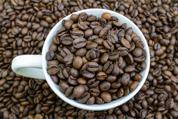 A white cup filled with coffee beans