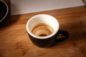 A nearly finished espresso reveals its telltale residue on the ceramic cup, highlighting coffee culture’s daily ritual of quick, robust shots and friendly cafés.