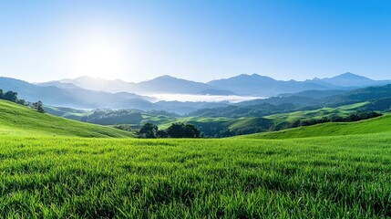 Sunrise over rolling green hills and misty mountains