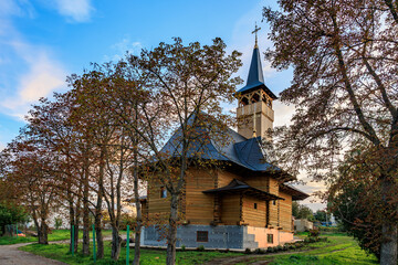 Obraz premium Traditional wooden church with tower in scenic autumn setting
