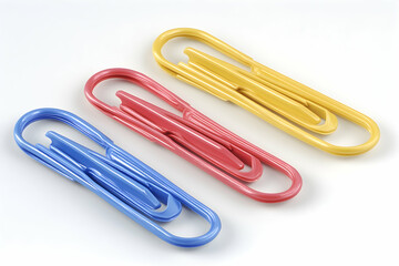 Obraz premium Colorful binder clips close-up shot, showcasing vibrant yellow, pink, and blue hues against a stark white background. Perfect for office supplies, organization, and stationery themes.