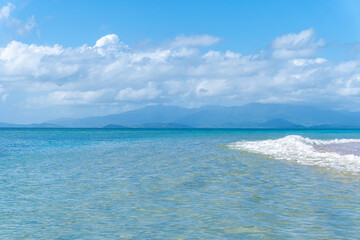 Mainland Puerto Rico seen from the clear waters of a Vieques beach, with turquoise ocean waves in the foreground