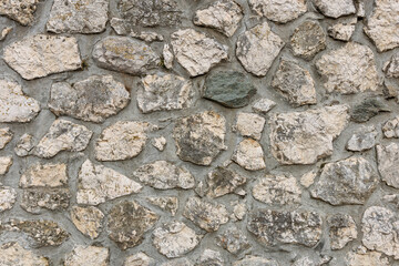Rustic stone wall with rough texture and uneven natural rocks pattern