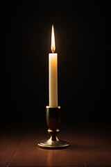 there is a lit candle sitting on a table in the dark