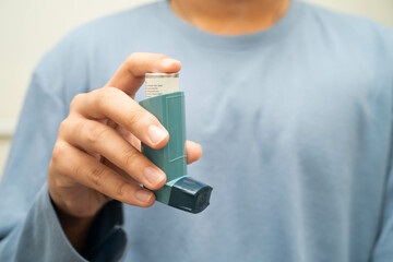 Asthma and chronic obstructive pulmonary disease COPD, Asian young man using metered dose inhaler...