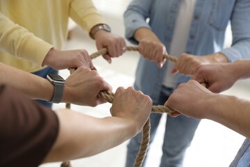 Unity concept. People holding rope together indoors, closeup