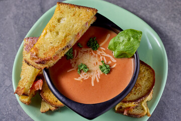 Grilled Cheese Sandwiches with Tomato Soup Garnished with Basil