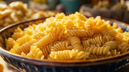 A vibrant bowl of spiral pasta sits on a rustic wooden table, surrounded by ingredients, evoking a warm, inviting atmosphere for cooking