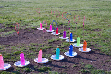 Various colorful bottles filled with liquid soap bubbles and sold in the open field