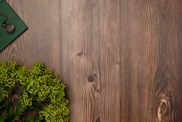 Book with vintage medallion flowers on wooden background. Flat lay, top view. Copy space