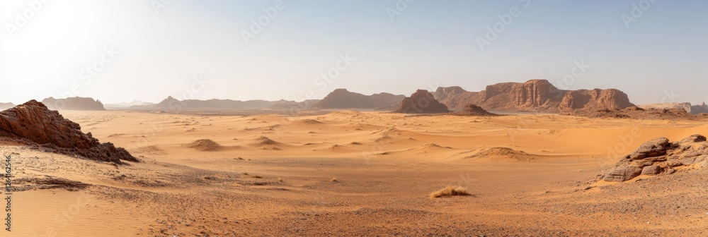 Poster vast desert landscape showcasing undulating sand dunes and rugged mountains under a clear sky in the