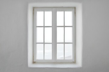 White framed window centered on a textured white wall
