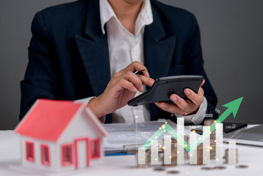 Mortgage and real estate finance concept with businessman using calculator. Homeownership planning, financial management, property loans, real estate growth, and investment strategies.