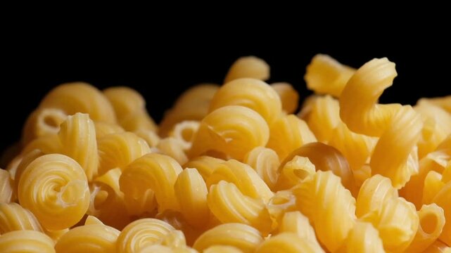 Raw macaroni pasta falls gracefully in stunning slow motion.