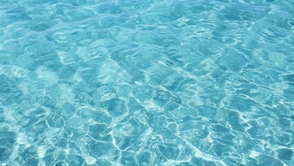 Blue ripped seawater in a swimming pool. Crystal clear ocean lagoon bay turquoise blue azure water surface, closeup natural environment. Tropical Mediterranean beach water background