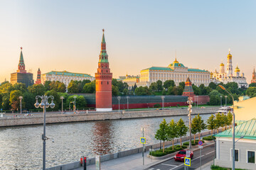 Obraz premium View of Kremlin with Vodovzvodnaya tower, Grand Kremlin Palace from repaired Bolshoy Kamenny Bridge in Moscow city on sunny summer day. Cruise ship sails on the Moscow river