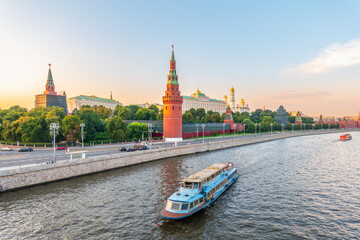 Obraz premium View of Kremlin with Vodovzvodnaya tower, Grand Kremlin Palace from repaired Bolshoy Kamenny Bridge in Moscow city on sunny summer day. Cruise ship sails on the Moscow river