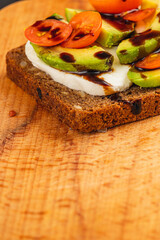 Delicious avocado toast topped with cherry tomatoes and balsamic glaze