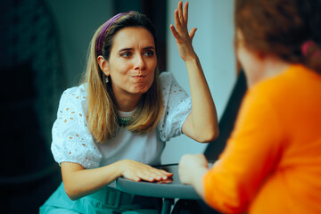 Women Sitting at a Table Fighting and Complaining. Two friends having negative feelings expressing...