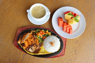 black hotplate rice vegetable fish chicken and meat  dinner with slice fruit