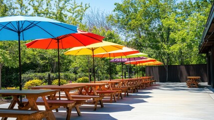 Fototapeta premium Colorful umbrellas shade picnic tables outdoors. Perfect for summer events, restaurants, or outdoor gatherings.