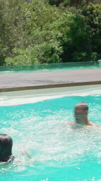 Happy couple jumping in the pool