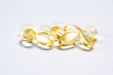 several cod liver oil capsules on a white background