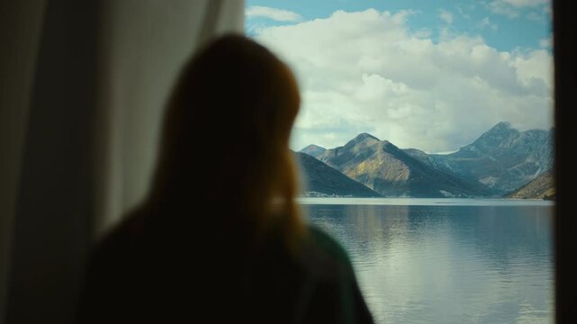 Woman silhouette in vindow relaxing view of Perast Villa overlooking the serene bay