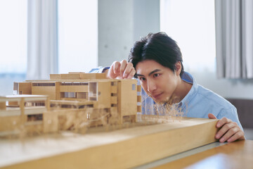 建築模型を見て建物を学ぶ日本人の建築学科の大学生